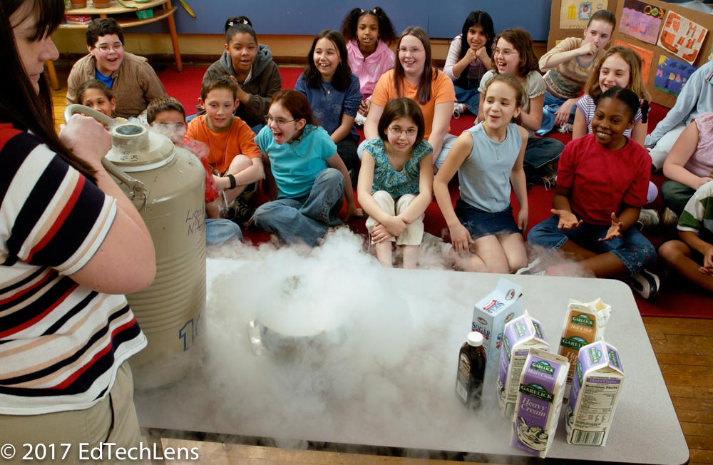 Excited fourth-grade students watch as scientist mom demonstrates qualities of liquid nitrogen to her daughter’s class.