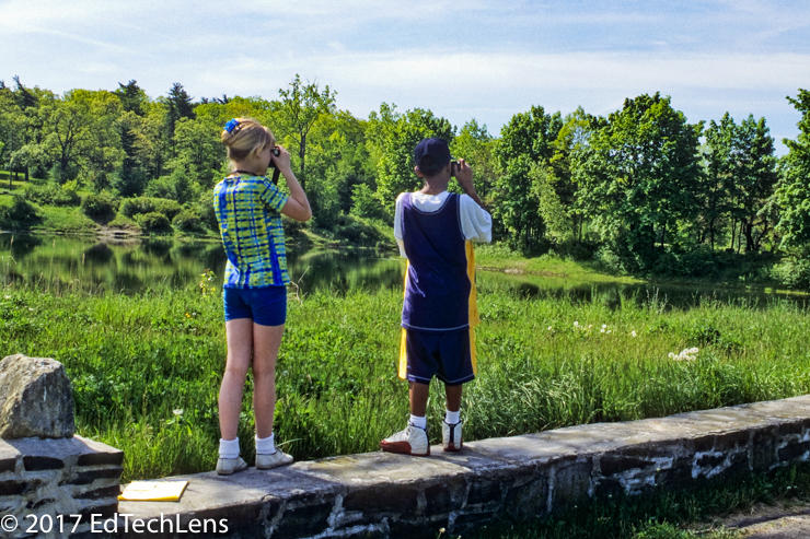 Two fifth-grade students photograph at a park near their school for a long-term project that involves documenting changes in the landscape throughout the seasons.